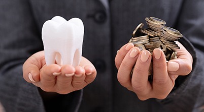 Tooth and coins in palms of hands