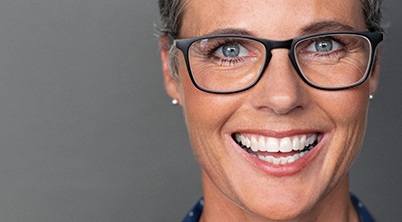 closeup of woman smiling with glasses on 