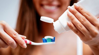 Woman holding a toothbrush and toothpaste