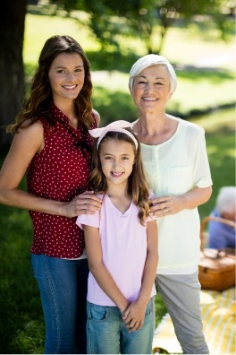 Three generations of woman smiling after restorative dentistry treatment