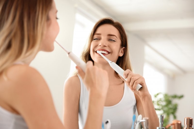 Young woman brushing with an electric toothbrush